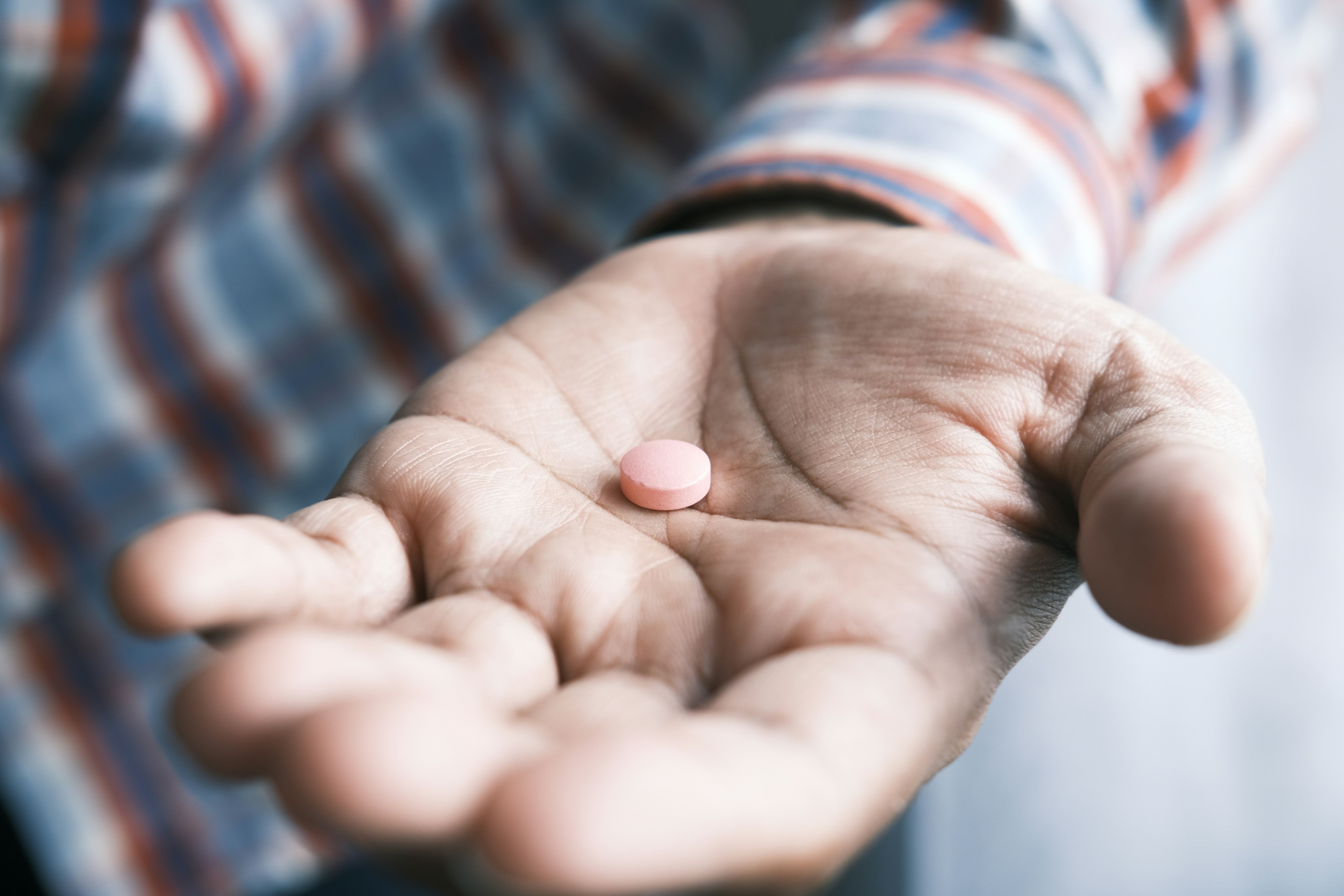 Close up of a hand holding pills